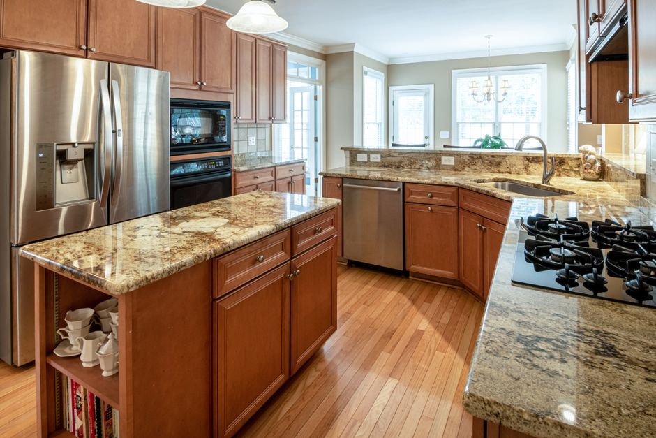 A luxurious kitchen interior featuring granite countertops and modern appliances.